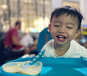 Cheerful baby boy sitting on high chair