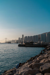 Sea by city against clear blue sky