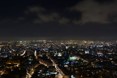 Illuminated cityscape against sky at night