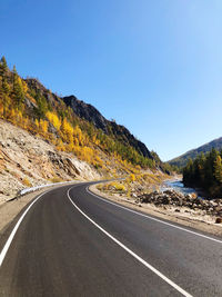 Road by mountain against clear sky