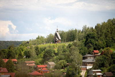 Rear view of woman sitting on mountain against sky