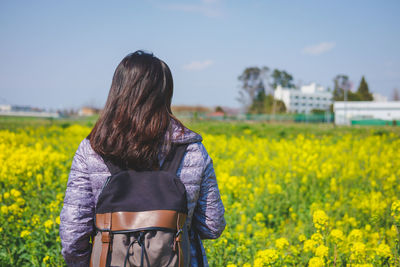 Rear view of woman standing on field