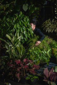 Young man standing amidst plants