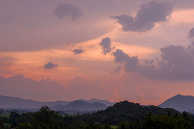 Scenic view of silhouette mountains against orange sky