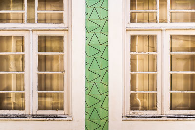 Facade of an old house in aveiro white wooden windows decorated by portuguese tiles in green