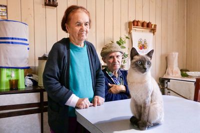 Couple looking at cat in home