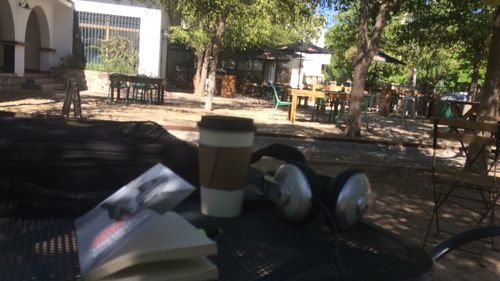 Close-up of open book on table against building