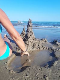 Woman building sand castle on beach