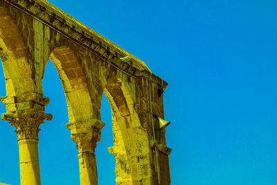 Low angle view of historic building against blue sky