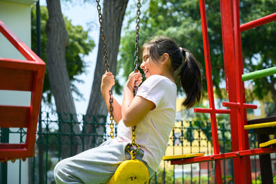 Happy little hispanic girl child having fun to playing in the park