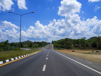 Road by trees against sky