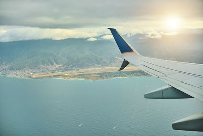 Cropped image of airplane wing against sky