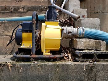 Close-up of yellow machine against wall