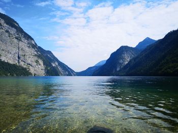 Scenic view of lake by mountains against sky