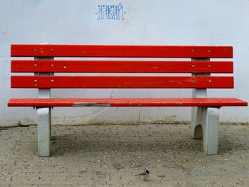 Empty bench against wall