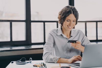 Young businesswoman using laptop at office