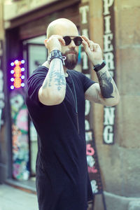 Midsection of man holding camera while standing outdoors