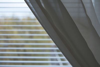 Cropped image of curtain against blinds