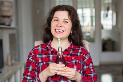 Portrait of smiling woman drinking drink