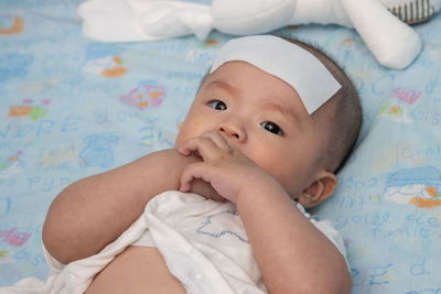 Portrait of cute baby lying on bed