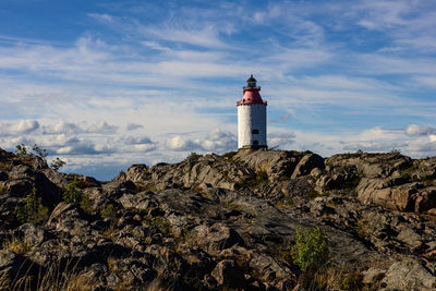 Lighthouse by sea against sky