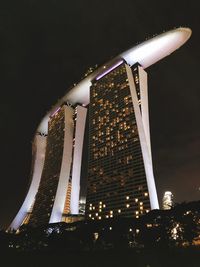 Low angle view of illuminated building against sky at night