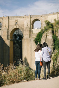 Rear view of people walking in front of historical building