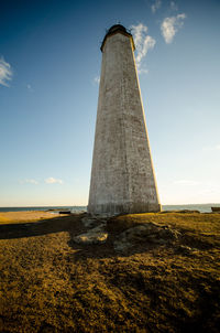 Low angle view of tower on field against sky