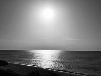 Scenic view of sea against bright sun