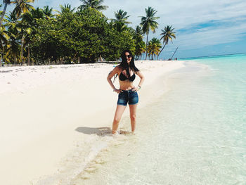 Full length of woman standing at beach 