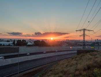 Railroad tracks against sky during sunset