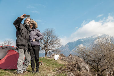 People on snow covered mountain against sky