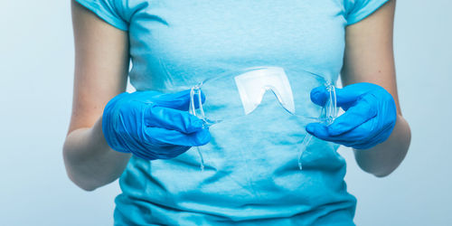 Midsection of man holding blue hair over white background