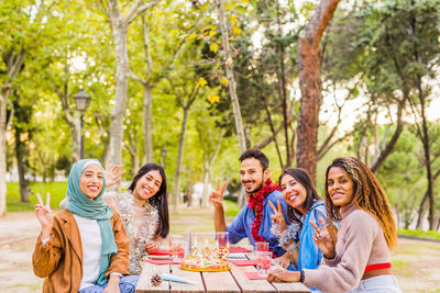 Portrait of smiling friends sitting at park