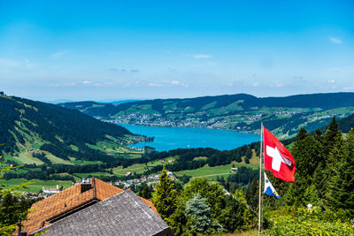 Scenic view of mountains and buildings against blue sky