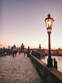 Street light on building against sky during sunset