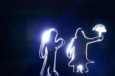Illuminated light painting on wall at night