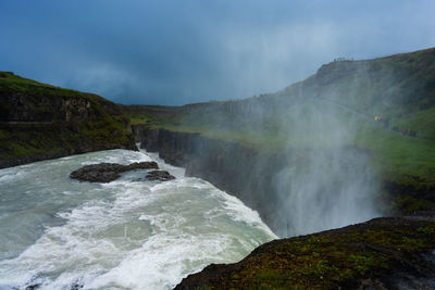 Scenic view of waterfall against sky