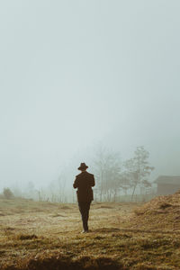 Man walking on land against sky