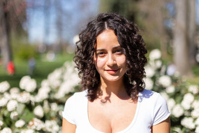 Young woman with curly hair in the park enjoying the sunshine