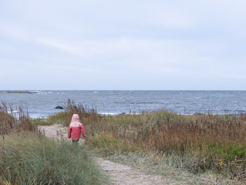 Girl walking towards sea