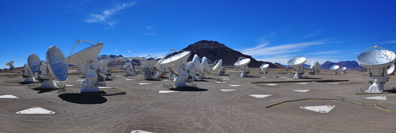 Panoramic view of radio telescopes against sky