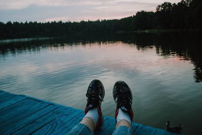 Low section of man on lake against sky