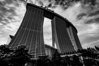 Low angle view of modern building against cloudy sky