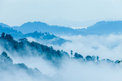 Scenic view of clouds covering mountains against sky