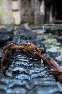 Close-up of rusty metal chain on wood
