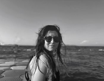 Portrait of woman wearing sunglasses against sea