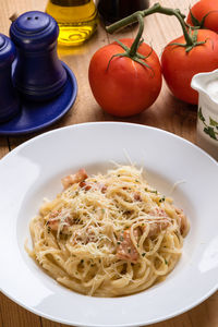 High angle view of spaghetti with carbonara in plate on table