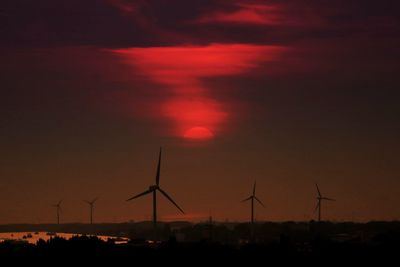 Silhouette wind turbine against sky during sunset