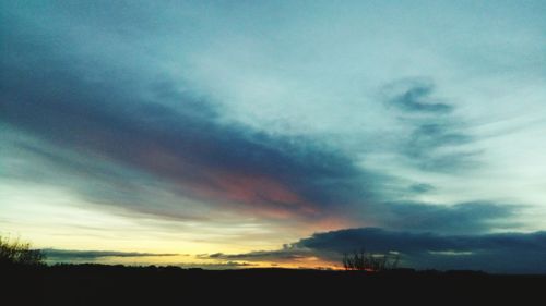 Silhouette of landscape against cloudy sky